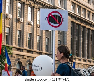 Bucharest/Romania - 09.19.2020: Woman Holding A Sign Board With The Picture Of A Face Mask In A Red Circle - No More Facemasks.. Protest In The University Square Against Wearing Face Masks.