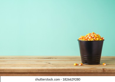 Bucket With Candy Corn On Wooden Table. Halloween Holiday Celebration Background