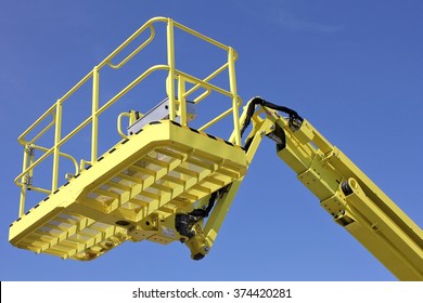 Bucket Of Cherry Picker Against Blue Sky