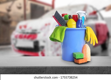 Bucket With Cleaning Supplies On Grey Stone Surface At Car Wash. Space For Text