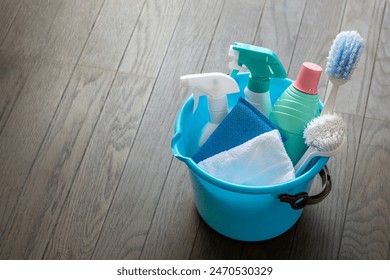 Bucket and cleaning tools on a wooden floor. - Powered by Shutterstock