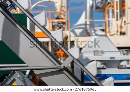 Bucket elevator conveyor system for industrial grain handling and agricultural seed transport, close up of plastic buckets on a belt at a processing facility. High quality photo