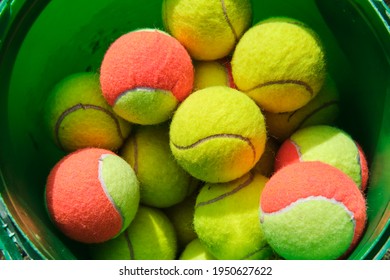 Bucket full of variously colored tennis balls, closeup shot from above - Powered by Shutterstock