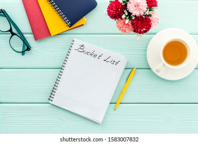 Bucket list. Blank notebook to write goals and wishes on green wooden office desk top-down mockup