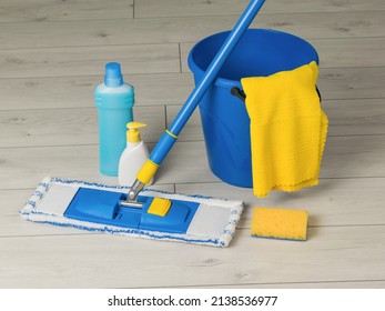 Bucket, mop, rag and detergents on the wooden floor. Home and office cleaning kit. The concept of maintaining cleanliness. Flat lay. - Powered by Shutterstock