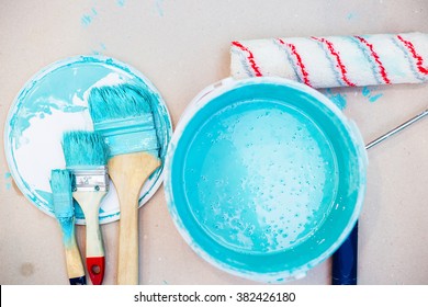 a bucket of paint and a paint tray and roller brush set