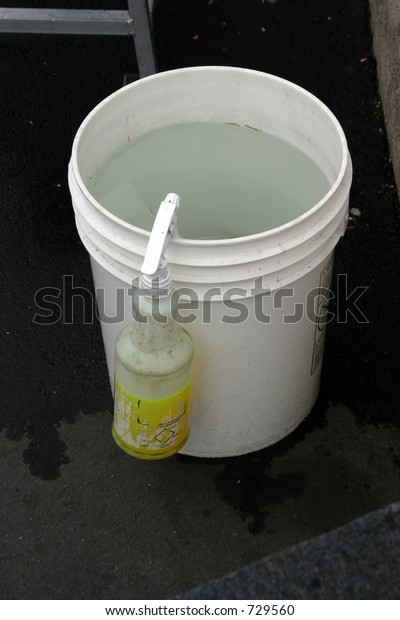 bucket of water\
with squirt bottle at a car\
wash
