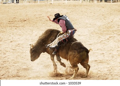 Bucking action during the bull rinding competition at a rodeo.