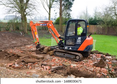 BUCKINGHAM, UK - February 13, 2016. Digger, Bulldozer Clearing Rubble In Preparation For Hard Landscaping A Garden In UK