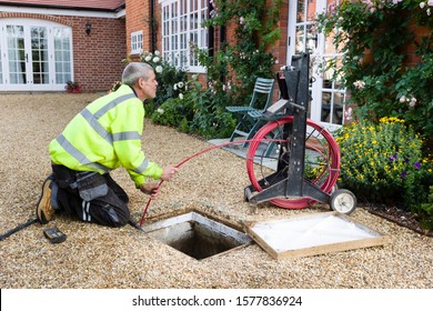 BUCKINGHAM, UK - October 16, 2019. A professional drain cleaning engineer inspects a blocked household drain 