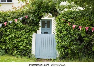 BUCKINGHAMSHIRE, UK - June 03, 2022. House Exterior With Blue Garden Gate, Front Door And Hedge