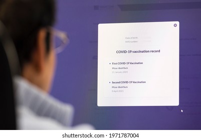 BUCKINGHAMSHIRE, UK - May 01, 2021. Covid 19 Vaccine Record. British Asian Indian Woman Checking Her Covid-19 Vaccination Record On An NHS Primary Care Patient Access Website.