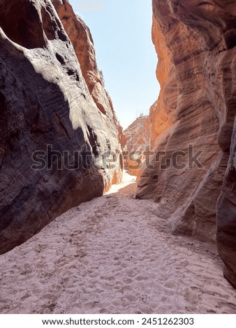 Buckskin Gulch with red canyon walls with a white sky and dark shadows