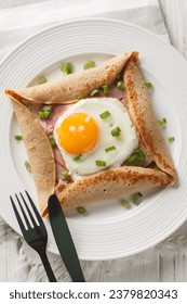 Buckwheat crepe galette with ham and egg for tasty healthy breakfast closeup on the plate on the table. Vertical top view from above - Shutterstock ID 2379820343