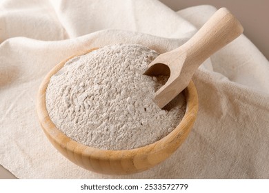 Buckwheat flour in a wooden bowl and raw buckwheat grain on cotton napkin on beige monochrome background. Alternative flour, gluten free flour, healthy nutrition - Powered by Shutterstock