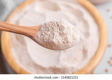 Buckwheat flour in a wooden bowl with wooden spoon, close up, top view, selective focus. Alternative flour, gluten free flour, healthy nutrition - Powered by Shutterstock