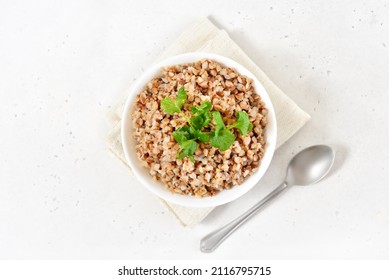 Buckwheat Porridge In White Bowl Over Light Stone Background.   Traditional Russian Food. Top View, Flat Lay