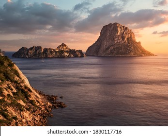  bucolic and beautiful landscape in Ibiza, Spain. It is Vedrá at dusk, in summer. Cliff of Cala D'Hort boat and mediterranean sea