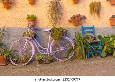 A bucolic scene of a wall full of hanging pots and a bicycle in a norther spanish village - Shutterstock ID 2232409777