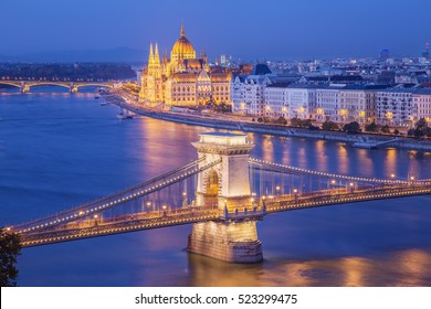 Budapest City Night Scene. View At  Chain Bridge, River Danube And Famous Building Of Parliament. Budapest City Is Capital Of East European Country Hungary.