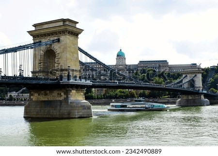 Budapest, Hungary - 08.04.2023: perspective view of the renovated Chain Bridge. green water of the Danube. The Buda Castle in the background. returning the bridge to the public after reconstruction 