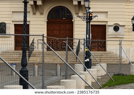 Budapest, Hungary - 10.20.2023. galvanized steel designated construction barricade, barrier and fence. connected metal panels. in the castle district by the prime minister's office. stucco elevation