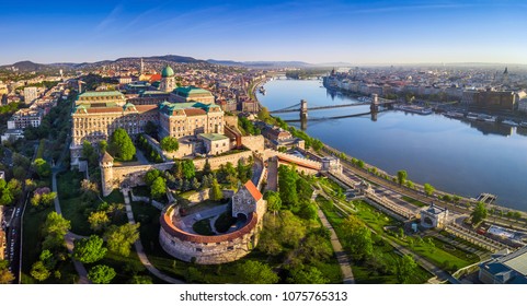 Budapest, Hungary - Aerial panoramic skyline view of Buda Castle Royal Palace with Szechenyi Chain Bridge, St.Stephen's Basilica, Hungarian Parliament and Matthias Church at sunrise with blue sky - Powered by Shutterstock