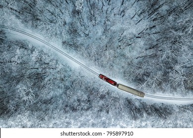 Budapest, Hungary - Aerial View Of Snowy Forest With Red Train On A Track At Winter Time, Captured From Above With A Drone At Huvosvolgy