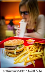 BUDAPEST, HUNGARY, April, 2013: Young Woman Eating A Big Mac Hamburger Menu In A McDonald's Restaurant. Illustrative Editorial. 