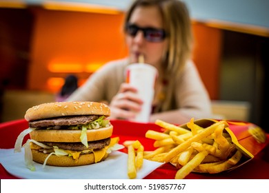 BUDAPEST, HUNGARY, April, 2013: Young Woman Eating A Big Mac Hamburger Menu In A McDonald's Restaurant. Illustrative Editorial. 