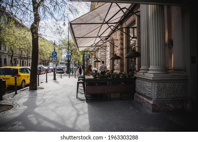 Budapest, Hungary. April 2018: Tourists sitting in a sidewalk cafe in the central street in Budapest, Andrassy Avenue.