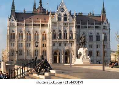 BUDAPEST, HUNGARY - April 21, 2022: Sculptures of the  poet Attila Jozsef and Count Gyula Andrassy in front of the Hungarian Parliament building. 