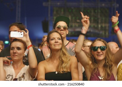BUDAPEST, HUNGARY - AUGUST 16, 2014: Women fans of Sziget music festival wait for a concert in front of a stage in first row. Sziget is one of biggest festivals in Europe