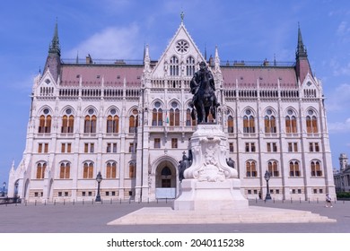 BUDAPEST, HUNGARY - AUGUST 19, 2021: Hungarian parliament building and a statue of Count Gyula Andrassy in front of it in Budapest on a sunny day
