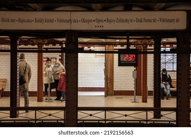 BUDAPEST, HUNGARY - FEBRUARY 27, 2022: Selective Blur On People Validating A Ticket On Budapest Metro Line 1 At Opera Metro Station, Wearing Face Mask During Covid 19 Coronavirus.

