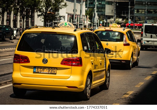 Budapest Hungary\
july 11, 2020 View of a traditional yellow Hungarian taxi for\
passengers driving through the streets of Budapest the capital and\
the most populous city of\
Hungary