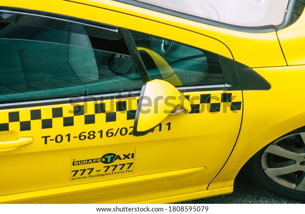 Budapest Hungary\
july 18, 2020 View of a traditional yellow Hungarian taxi for\
passengers driving through the streets of Budapest the capital and\
the most populous city of\
Hungary