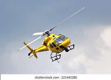 BUDAPEST, HUNGARY - JULY 26, 2014: Yellow Helicopter Eurocopter AS-355N Ecureuil 2 At The Sky Above The Hungaroring Formula One Race Track.