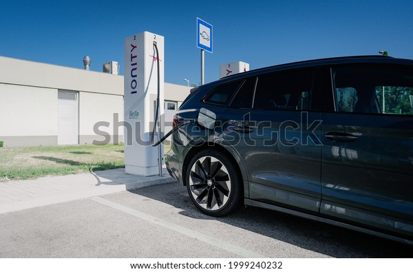 Budapest, Hungary - JUNE\
27, 2021: Multiple IONITY charging station charging a electric\
vehicle (NEW SKODA ENYAQ) at a DC charger .Electric mobility\
environment friendly