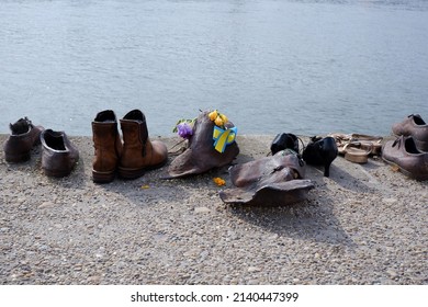 Budapest, Hungary - March 29, 2022: Shoes On The Banks Of The Danube Holocaust Memorial - Shoes With A Cockade Of The Ukrainian National Color In Memory Of The Victims Of The Ukrainian-Russian War