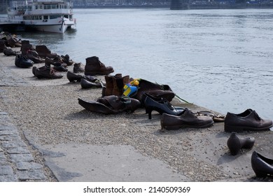 Budapest, Hungary - March 29, 2022: Shoes On The Banks Of The Danube Holocaust Memorial - Shoes With A Cockade Of The Ukrainian National Color In Memory Of The Victims Of The Ukrainian-Russian War