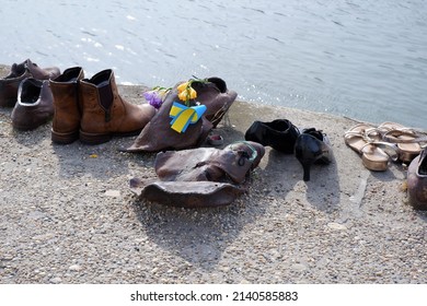 Budapest, Hungary - March 29, 2022: Shoes On The Banks Of The Danube Holocaust Memorial - Shoes With A Cockade Of The Ukrainian National Color In Memory Of The Victims Of The Ukrainian-Russian War