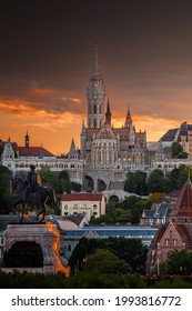 Budapest, Hungary - St Matthias Church and Fisherman's Bastion (Halaszbastya) with Statue of Gyula Andrassy in foreground and beautiful golden sunset and dramatic sky on a summer afternoon