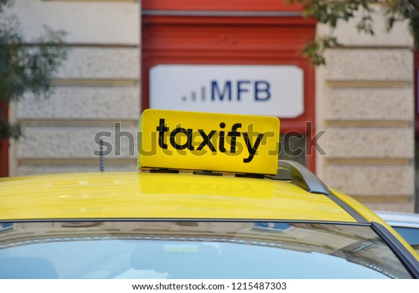 Budapest taxi\
yellow light sign on city background with advertise on the wall.\
Budapest, Hungary - 27.09.2018\
