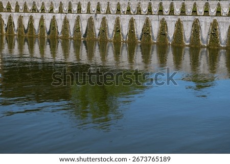 In Budapest, triangular concrete weirs line the riverbank, creating a rhythmic pattern.