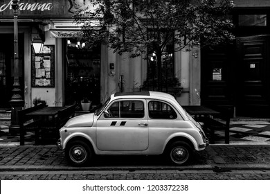 Budapest/Hungary - 10.03.2018, An Old Car In Front Of An Italian Restaurant. Black And White Photo