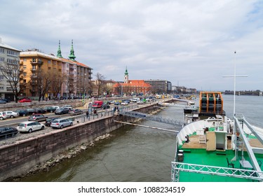 BUDAPEST,HUNGARY - APRIL 06,2018 : Buda Embankment Sight From A Cruise Boat.Batthyany Square With Piers,spire Of Saint Francis Wounds Church And The
Busy Quay.