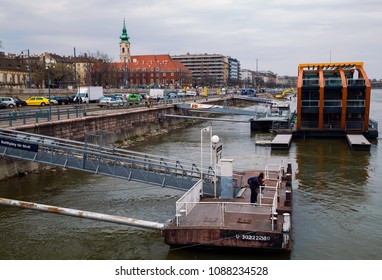 BUDAPEST,HUNGARY - APRIL 06,2018 : Buda Embankment Sight From A Cruise Boat.Batthyany Square With Piers,spire Of Saint Francis Wounds Church And The
Busy Quay.