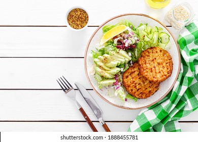 Buddha Bowl Dish With Grilled Chicken Burgers, Cucumbers, Avocado And Fresh Lettuce Salad For Lunch, Top View.