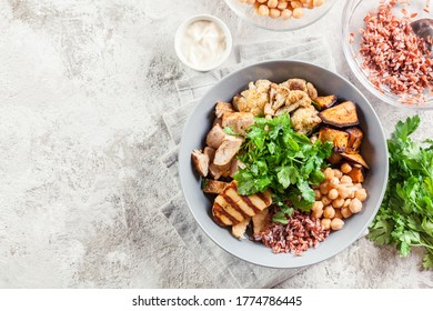 Buddha Bowl Lunch With Chicken And Red Rice, Chickpea, Cauliflower And Halloumi Cheese. Healthy Food Concept